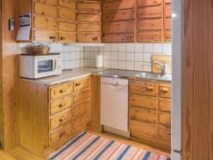 eine Küche mit Holzschränken, einer Mikrowelle und einer Spüle in der Unterkunft Holiday Home Mäntylä a-osa by Interhome in Nissi + 15 Fotos