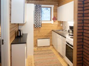 a small kitchen with white cabinets and a window at Holiday Home Viipusjärvi 11 by Interhome in Ruka