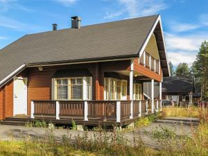a house with a porch and a gambrel at Holiday Home Laulelevi by Interhome in Levi