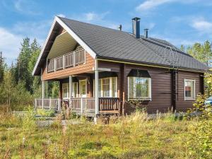 a wooden house with a black roof at Holiday Home Laulelevi by Interhome in Levi