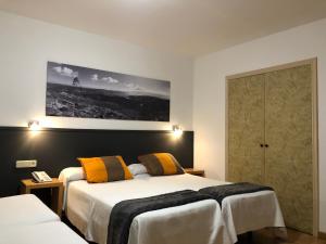 ビーゴにあるHotel del Mar Vigoのベッド2台が備わる客室で、壁に絵が描かれています。