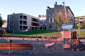 a park with a playground with a slide and benches at Apartamento en c/ Peroneros in Latas