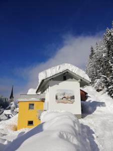 a house covered in snow with a pile of snow at Ferienhaus Sonnberg in Hüttau