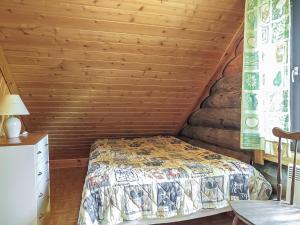 - une chambre avec un lit et un mur en bois dans l'établissement Holiday Home Jäkälä by Interhome, à Kyrö