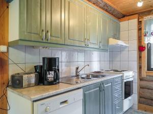 a kitchen with green cabinets and a sink at Holiday Home Jäkälä by Interhome in Kyrö +10 photos