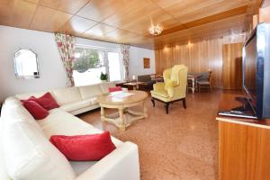 a living room with a white couch and a table at Landhaus Fuchsenstube in Schruns-Tschagguns