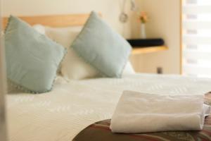 Una cama con dos almohadas y una toalla. en Angelica's Rental House, en Puerto Natales