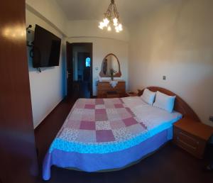 a bedroom with a bed with a quilt on it at Makedonia Studios at Harbour of Kamiros Skala in Kamiros