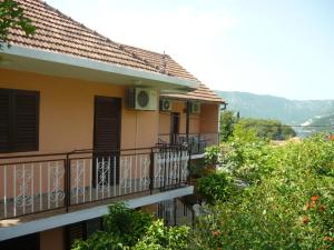a house with a balcony with trees and mountains in the background at Rooms Banićević in Risan