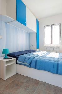 - une chambre bleue et blanche avec un lit et une étagère dans l'établissement Casetta di Ameglia, à Ameglia