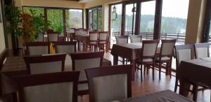 a dining room with tables and chairs and windows at Vila Monix Club Zlatibor in Zlatibor