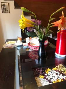 una mesa con un jarrón de flores y un plato de dulces en Casa Salkantay Cusco, en Cusco