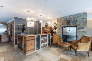 a living room with a tv and a stone wall at Chamois d'Or Hotel in Les Gets