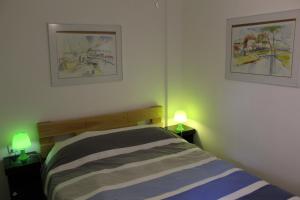 a bedroom with a bed and two lamps on tables at Villa Kibel Apartments in Eilat