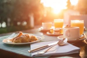 a table with a plate of food and a cup of coffee at Sun Gardens Dubrovnik in Dubrovnik