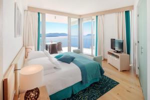 a bedroom with a large bed with a view of the ocean at Sun Gardens Dubrovnik in Dubrovnik