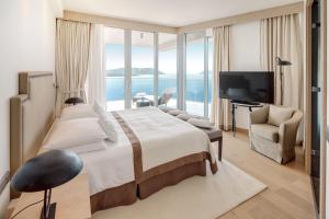 a bedroom with a large bed and a large window at Sun Gardens Dubrovnik in Dubrovnik