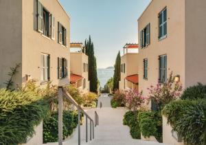 a staircase between two buildings with pink flowers at Sun Gardens Dubrovnik in Dubrovnik