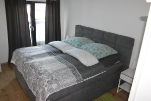una cama gris con almohadas en una habitación en Ferienwohnung Schamne en Gernsbach