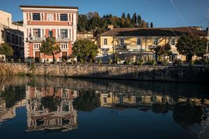a reflection of a building in a body of water at Waterfall San Lorenzo in Isola del Liri