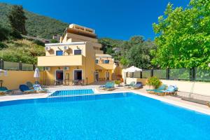 a villa with a swimming pool in front of a house at Corfu Secret in Ipsos