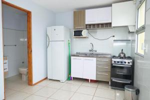a kitchen with a white refrigerator and a sink at Palmas del Caribe in Punta Del Diablo
