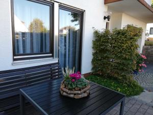 una mesa de madera con flores en el porche en Annettes Ferienwohnung, en Michelstadt