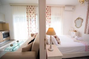 a white bedroom with a bed and a couch at Thasos Blue Apartments in Prinos
