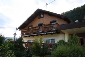 ein Haus mit einem Balkon, der mit Pflanzen bewachsen ist in der Unterkunft Pension Wolf in Steindorf am Ossiacher See + 22 Fotos
