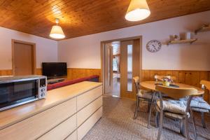 a kitchen and dining room with a table and a microwave at Chata HANA in Jeseník