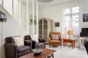 a living room with two chairs and a table at The Coach House Montpellier in Cheltenham