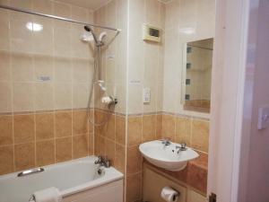 La salle de bains est pourvue d'un lavabo, d'une baignoire et de toilettes. dans l'établissement Corn Mill Lodge Hotel, à Leeds