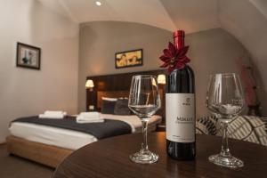 a bottle of wine sitting on a table with two wine glasses at Hotel Dolce International in Skopje