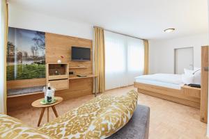 a hotel room with a bed and a tv at Hotel & Restaurant Pötter in Emsdetten