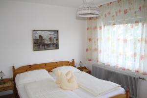 ein Schlafzimmer mit einem Bett, auf dem ein Paar Schuhe liegt in der Unterkunft Pension Wolf in Steindorf am Ossiacher See