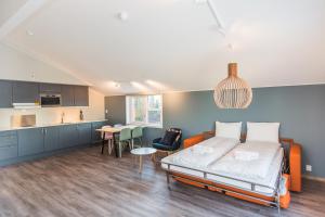 a large room with a bed and a kitchen at MAYA Apartments - Kasjotten in Lillestrøm
