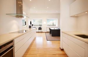 een keuken met witte kasten en een eetkamer bij Europahuset Apartments in Kopenhagen