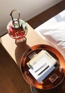 een tafel met een plaat en een lamp op een bed bij SWEETS - Buiksloterdraaibrug in Amsterdam +10 foto's