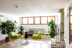 フュッセンにあるユーグントヘルベゲ フュッセンの緑の椅子、テーブル、窓が備わる客室です。