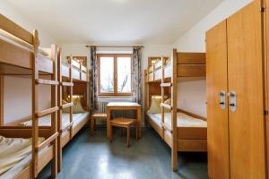 a room with bunk beds with a table and a window at Jugendherberge Füssen in Füssen