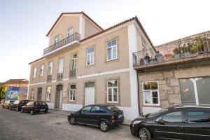 a building with cars parked in front of it at Casa das Muralhas in Covilhã