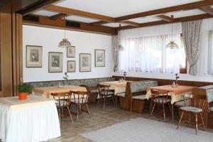 ein Restaurant mit Tischen und Stühlen in einem Raum in der Unterkunft Pension Wolf in Steindorf am Ossiacher See