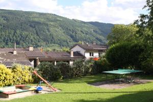 ein Hinterhof mit einer Tischtennisplatte im Gras in der Unterkunft Pension Wolf in Steindorf am Ossiacher See