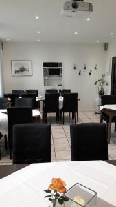 uma sala de jantar com mesas e cadeiras e flores sobre uma mesa em Haus Bergmann em Harsewinkel