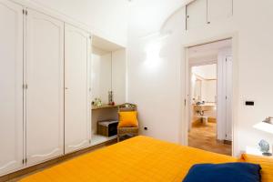 a bedroom with a bed and a yellow blanket at Casa Dorothea 2 in Positano