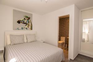 1 dormitorio con 1 cama y una pintura de un caballo en Los Gracioseros BUNGALOW 2, en Puerto del Carmen