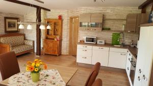 Una cocina con una mesa con un jarrón de flores encima. en Ferienhof Gold, en Waischenfeld