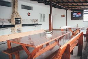 two wooden benches in a room with a table at Souza Reis Flat in São Thomé das Letras