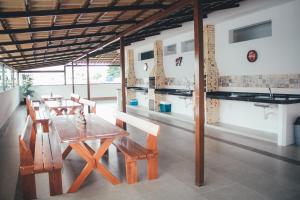 a dining room with a wooden table and chairs at Souza Reis Flat in São Thomé das Letras
