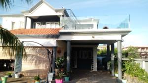 a large white house with a porch at Villa FRANCOISE in Pereybere